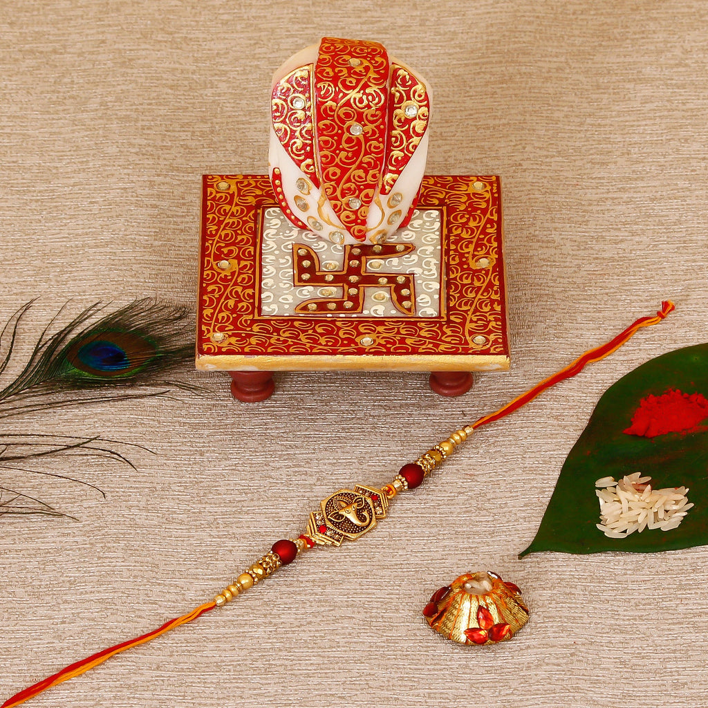 Designer Religious Ganesha Rakhi with Ridhi Sidhi Marble chowki and Roli Tikka Matki Kafalo