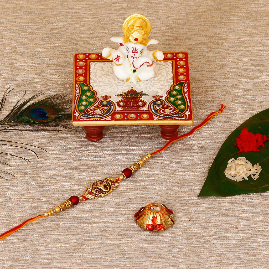 Designer Religious Ganesha Rakhi with Lord Ganesha Marble Chowki and Roli Tikka Matki Kafalo