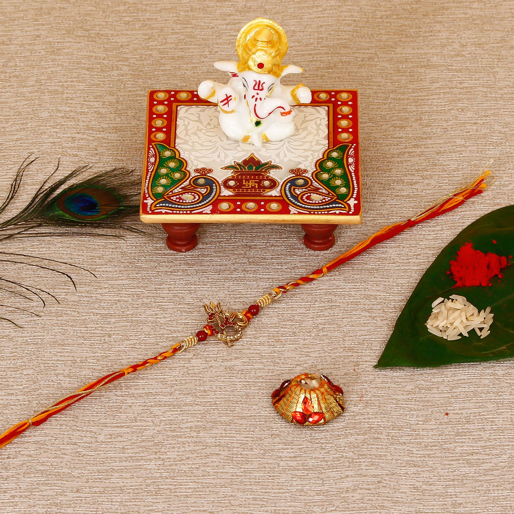Designer Religious OM Rakhi with Lord Ganesha Marble Chowki and Roli Tikka Matki Kafalo