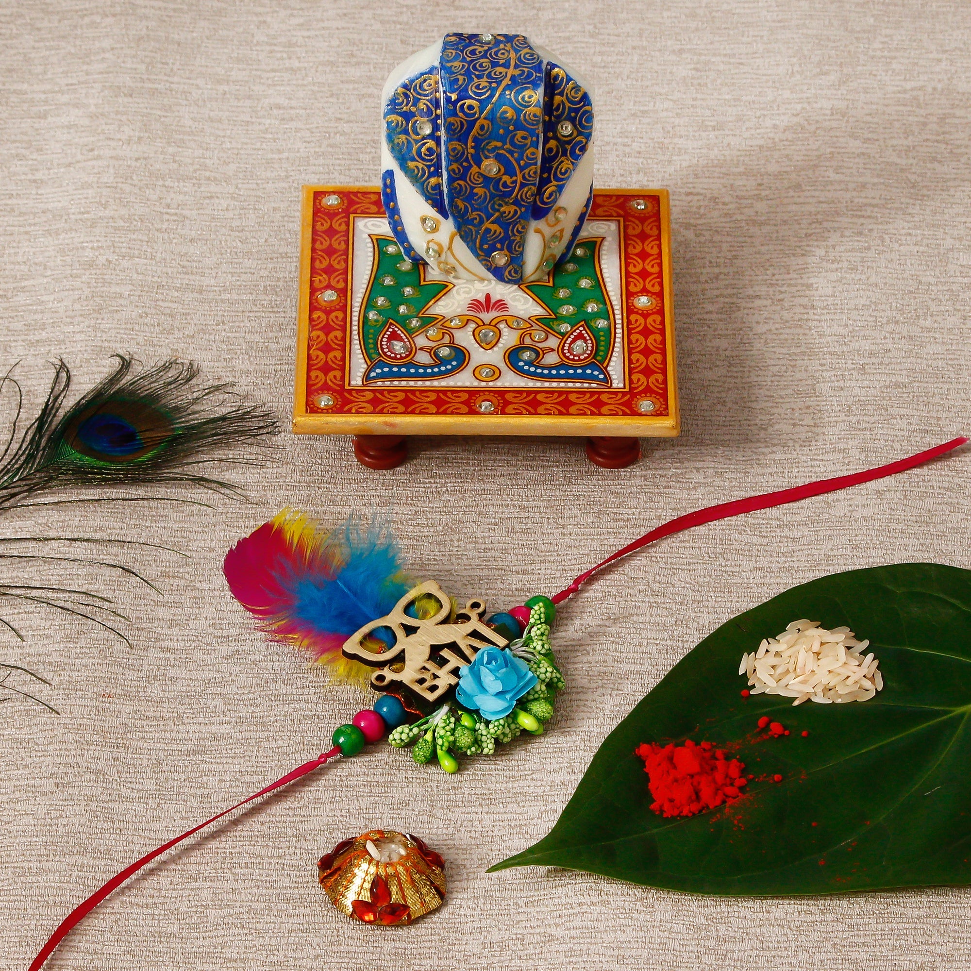Designer Rakhi with Lord Ganesha on Marble Chowki and Roli Tikka Matki Kafalo