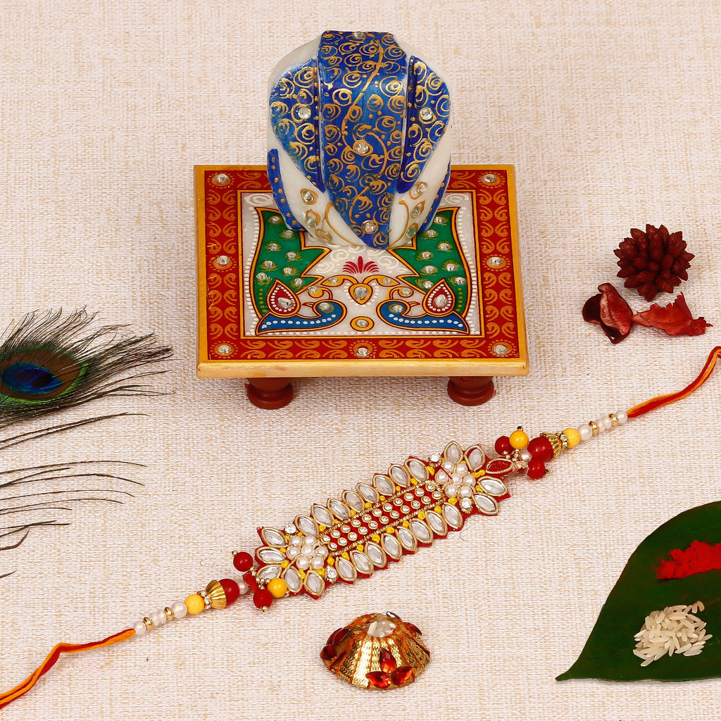 Designer Rakhi with Lord Ganesha on Marble Chowki and Roli Tikka Matki Kafalo