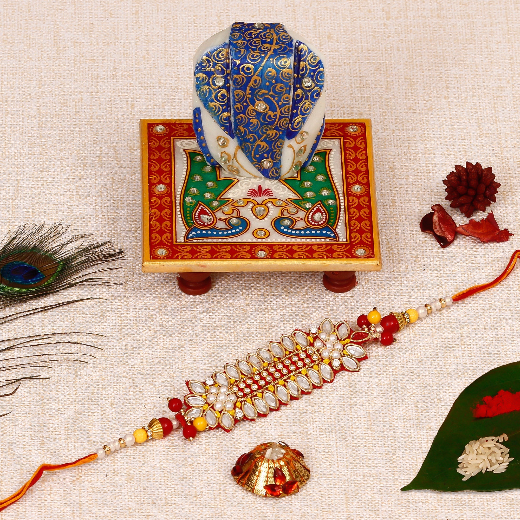 Designer Rakhi with Lord Ganesha on Marble Chowki and Roli Tikka Matki Kafalo