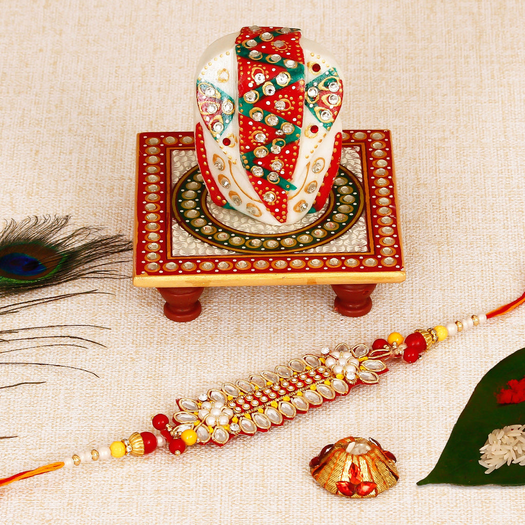 Designer Rakhi with Lord Ganesha on Kundan Studded Marble Chowki and Roli Tikka Matki Kafalo