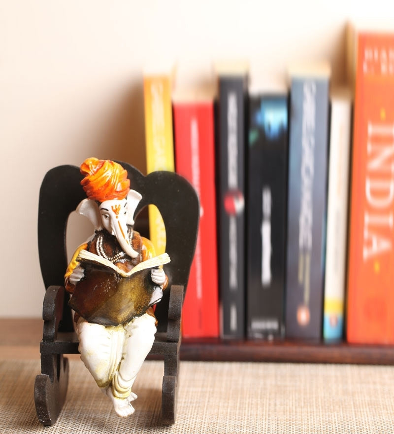 Orange Polyresin Lord Ganesha Idol reading Book on Wooden Chair Kafalo