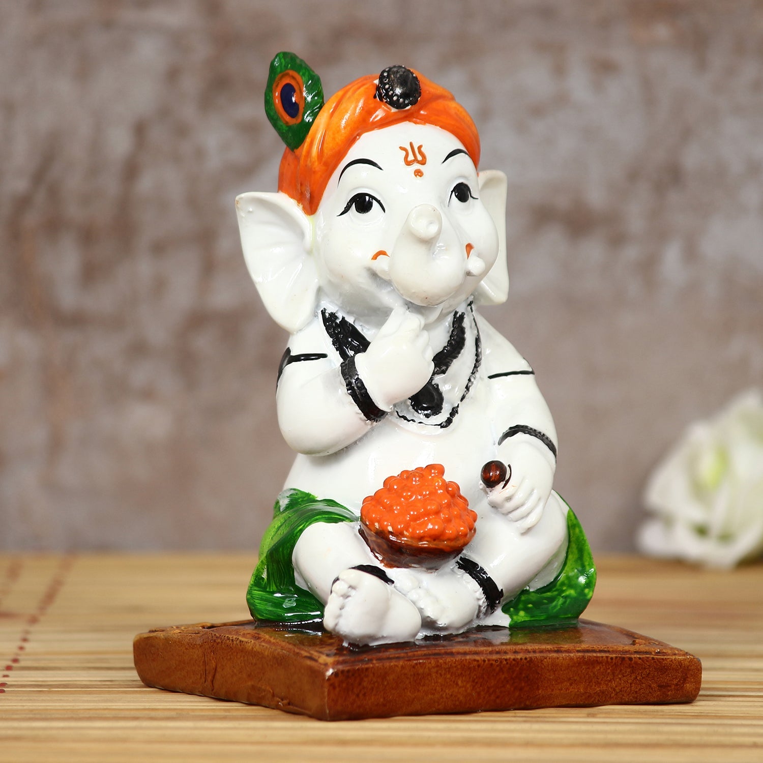 Decorative Polyresin Lord Ganesha Idol eating Ladoo in Lord Krishna Avatar (White, Orange, Green) Kafalo