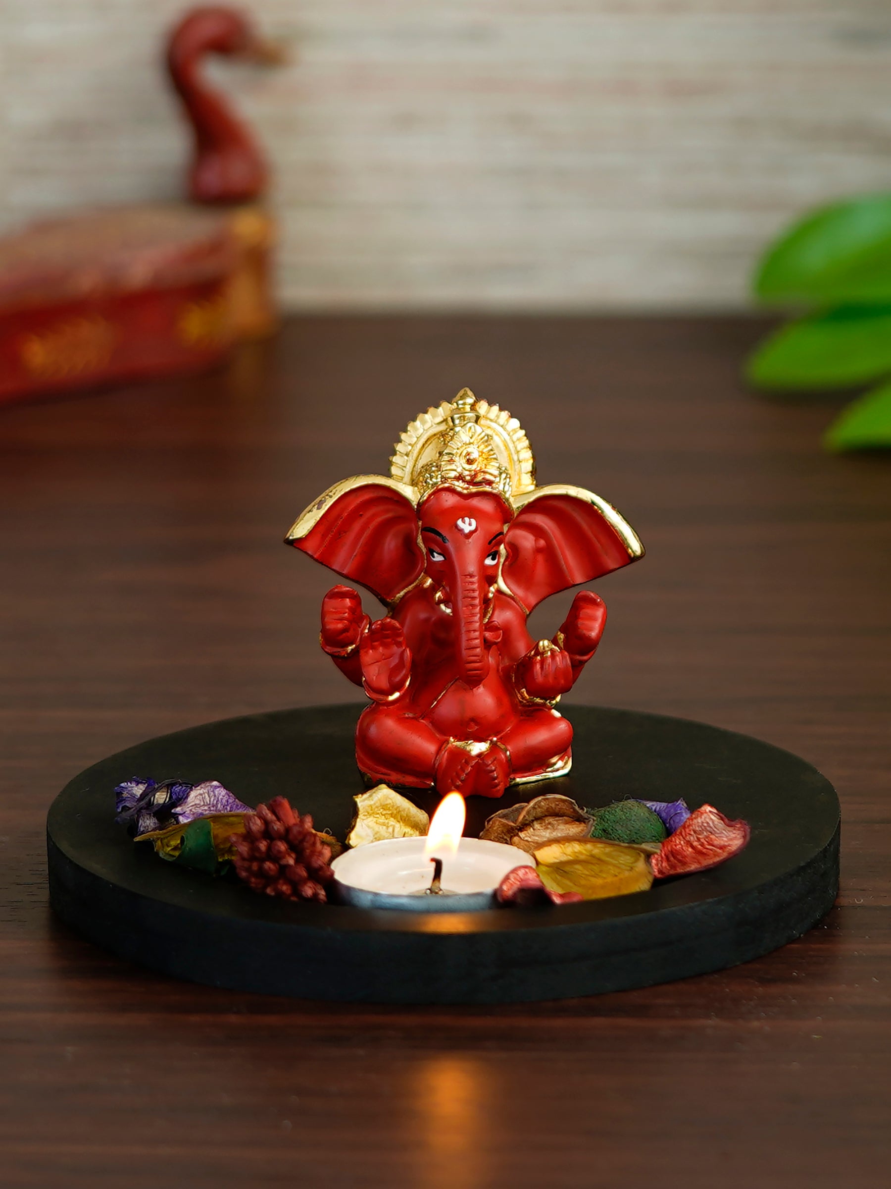 Gold Plated Red Ganesha Idol with Wooden Base, Fragranced Petals and Tealight Kafalo